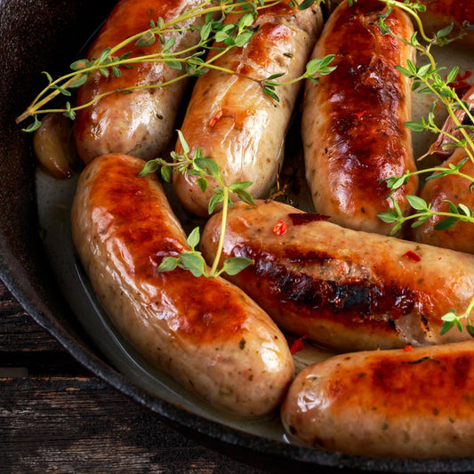 Grilled wild boar game sausages with herbs on a plate